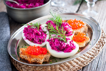 Stuffed eggs with beets and salted fish, horizontal