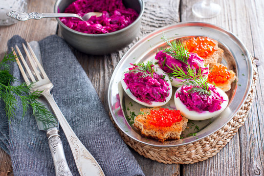 Stuffed eggs with beets and salted fish, horizontal