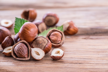 Hazelnuts and hazelnut leaves on the wooden table.