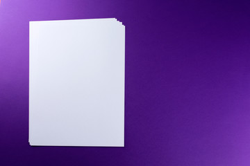 Blank sheets of paper purple background