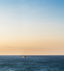 Calm sea and cloudless orange evening sky.