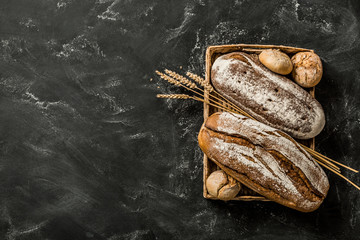 Bakery - rustic crusty loaves of bread and buns on black