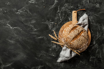 Bakery - round loaf of rustic bread on black background