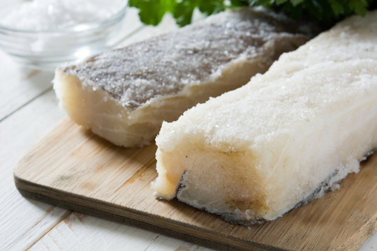 Salted dried cod on white wooden table. Typical Easter food