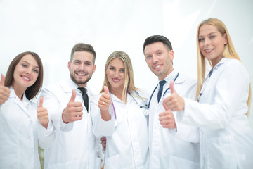 Portrait of a doctor and medical team showing thumb up