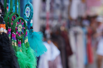 Crafts from feathers of different colors, Indian dream catchers on the market