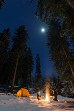 couple camping with campfire and tent outdoors