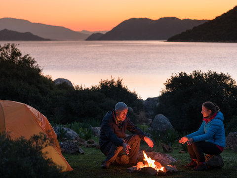 couple camping with campfire and tent outdoors