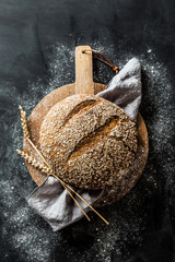 Bakery - round loaf of rustic bread on black background