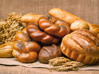 Closeup of a beautiful still-life from bread, pastry products with wheat ears, poppy seeds and buns.