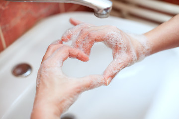 Fototapeta premium Soapy hand making heart shape