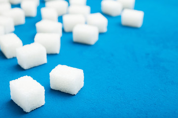 White sugar cubes on a blue vintage background. Copy space.