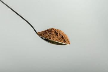 Spoon with cocoa on white background