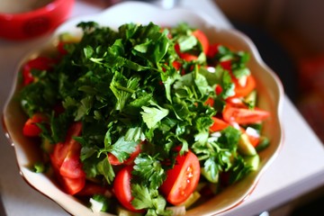 Healthy vegetarian Salad on the white plate. tomato and parsley salad top view
