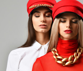 Two young sexy brunette woman in red and brown peaked cap together