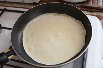 a man cooking pancakes in a frying pan