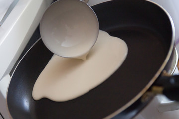 a dough for pancakes poured int a frying pan