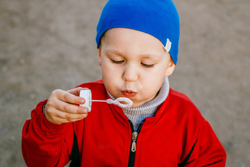 boy inflates soap bubbles