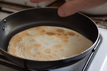 a man cooking pancakes in a frying pan