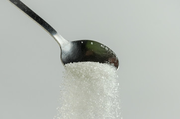 Naklejka na ściany i meble Spoon with sugar on a white background