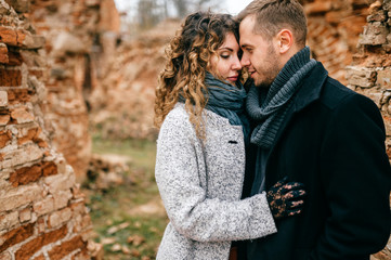 Closeup portrait of loving pair. Two lovers outdoor standing cheek to cheek. Man with woman hugs. Tender, emotional, sensual girl and boy in love. Male and female enjoying each other in castle ruins.