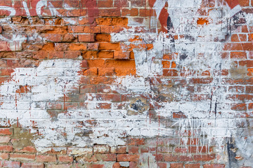 grunge textured background. old wall of broken brick smeared with white paint.