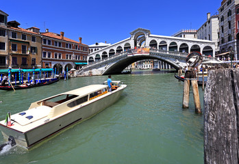 Fototapeta na wymiar Venice historic city center, Veneto rigion, Italy - view on the Rialto Bridge with vaporetto water taxis and gondolas on the Grand Canal