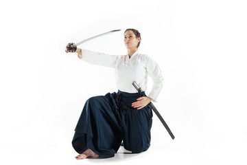 Aikido master practices defense posture. Healthy lifestyle and sports concept. Woman in white kimono on white background.