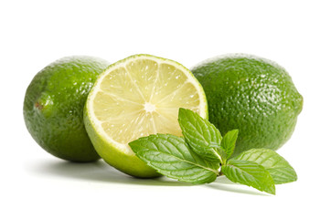 two limes with half of a juicy lime with leaves of mint isolated on white background