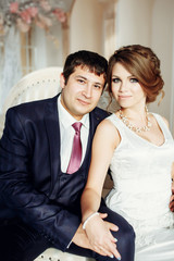 Groom and bride posing and smiling in studio for wedding shot. Wedding. Wedding day. Beautiful bride and elegant groom after wedding ceremony. 