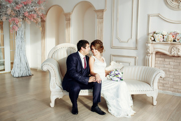 Obraz premium Groom and bride posing and smiling in studio for wedding shot. Wedding. Wedding day. Beautiful bride and elegant groom after wedding ceremony. 
