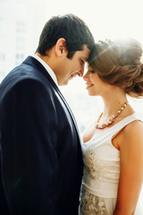 Groom and bride posing and smiling in studio for wedding shot. Wedding. Wedding day. Beautiful bride and elegant groom after wedding ceremony. 