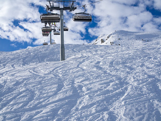 Ski lift and ski slope with skiers under it on sunny winter day with blue sky. Alpine resort Meribel, France. Europe, january, 2018