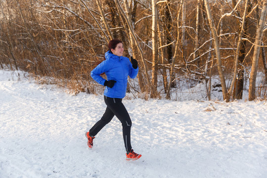 Photo of athlete in blue jacket on run in winter