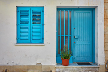 Typical exterior of Greek traditional town street with colorful buildings and marine blue door