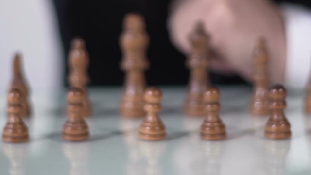 Chess competition, man in suit moving pawn on chessboard, business decision