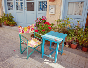 Fototapeta na wymiar Blue shutters window and a table on sidewalk