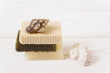 hand made soap with sea shells.white wooden background.