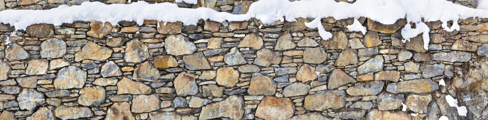 Verschneite Natursteinmauer