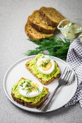 Avocado egg spring open sandwich on concrete background. Selective focus, close up, space for text.