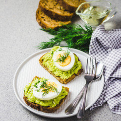 Low carb avocado egg toasts on concrete background. Selective focus, close up, space for text.