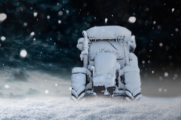 Zugeschneiter Traktor im Schnee bei Schneefall