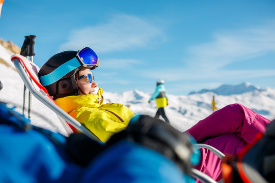 Picture of smiling sportswoman lying on winter deckchair
