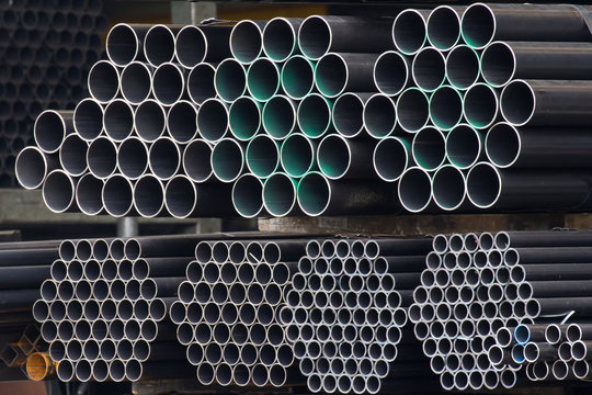 black steel pipes on shelf in stock yard of factory