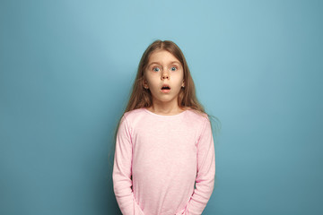 Fototapeta premium The surprise. Teen girl on a blue background. Facial expressions and people emotions concept