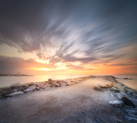 Fototapeta na wymiar Stone beach shore Barcelona at dramatic sunrise