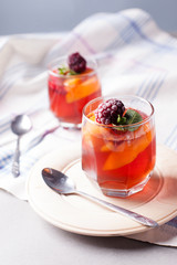 portioned fruit dessert in glass cups kremankah - jelly with fruit and mint, low-calorie summer snack