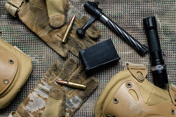 Carbine clip, ammo, gloves  and shutter lies on a background.