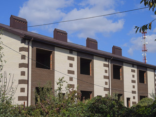 An apartment building under construction with a metal corrugated roof.