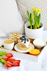 Cup with Cappuccino and Homemade Pancakes Sour Cream Berries Granola Orange Healthy Breakfast Morning Concept Woman's 
Day Flowers Tulips Daffodils